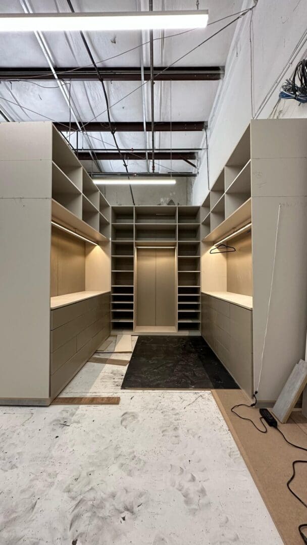 A large walk in closet with many shelves and drawers.